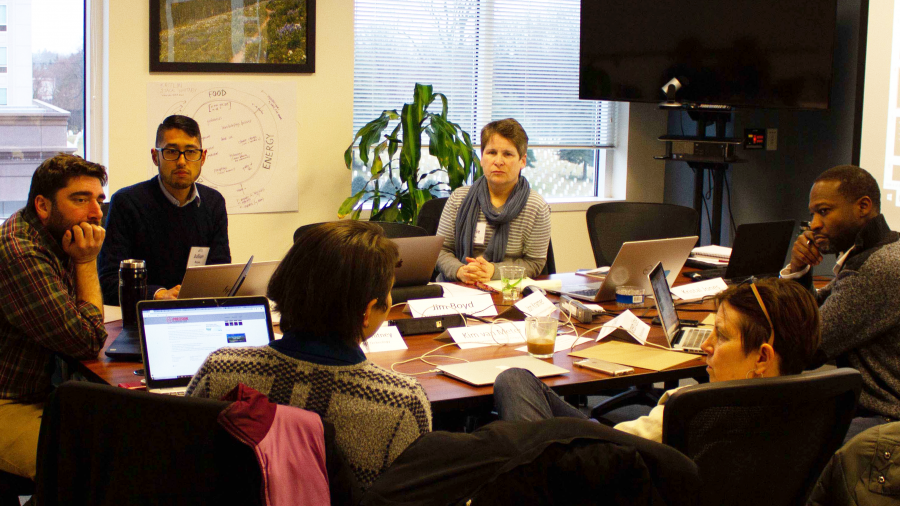 Participants in a DTMS workshop gathered around a table having a discussion