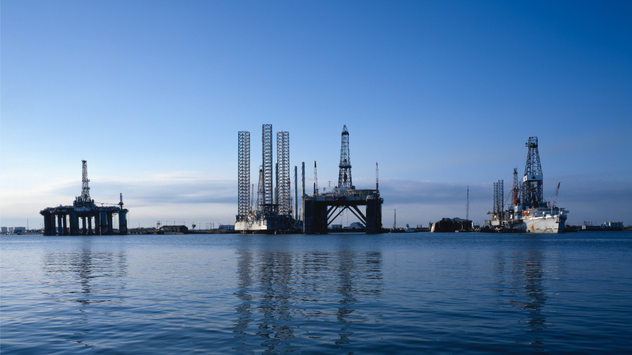 Oil rigs on the water with a blue-sky background