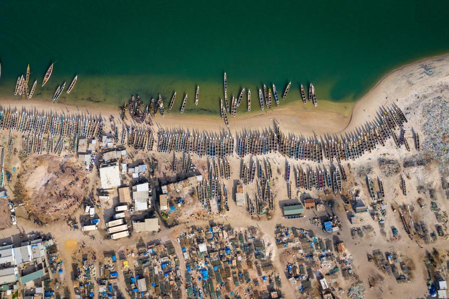 An aerial view of a fishing village with numerous boats along the coast