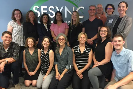 The Science of Knowledge Use team gathered in a group photo in front of the SESYNC sign