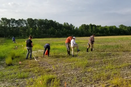People in an agricultural field gathering samples